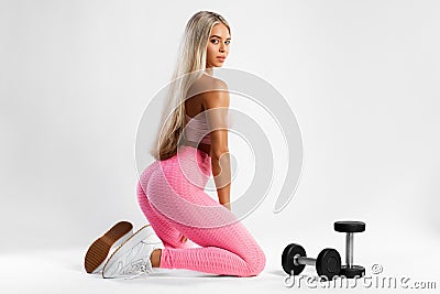 Fitness woman in leggings on gray background. Athletic girl with beautiful butt Stock Photo