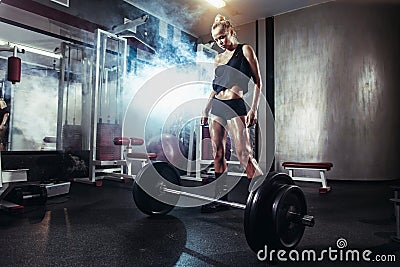 Fitness woman prepares for exercising with barbell in gym Stock Photo