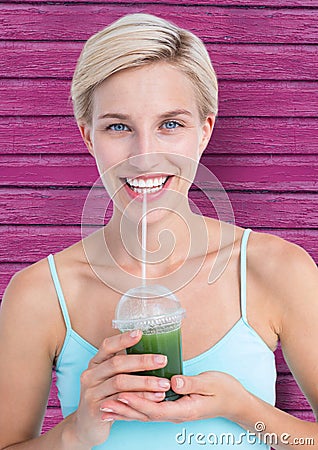fitness woman taking a healthy juice with pink wood background Stock Photo