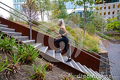 Fitness women running fast intervals in stairs in city park Stock Photo