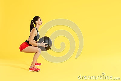 Fitness workout. Woman exercising squats with med ball at studio Stock Photo