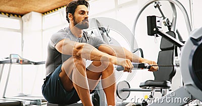 Fitness young man using rowing machine Stock Photo