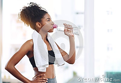 Fitness, young woman athlete and water or bottle for exercise hydration or after workout with towel and in gym Stock Photo