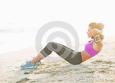 Fitness young woman doing abdominal crunch on beach Stock Photo
