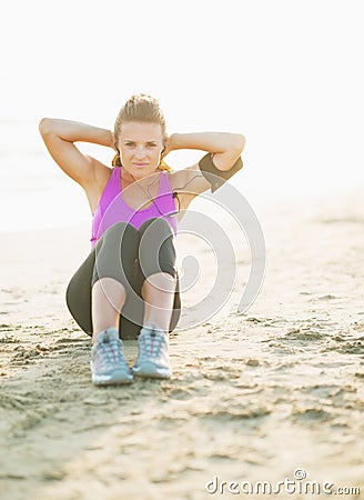 Fitness young woman doing abdominal crunch on beach Stock Photo