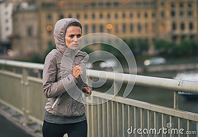 Fitness young woman jogging in rainy city Stock Photo