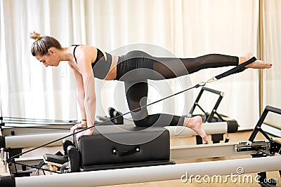Fitted woman doing diagonal stabilization with strap Stock Photo