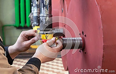 Fitter to reel up the seam fum tape on the connection in the gas pipeline Stock Photo