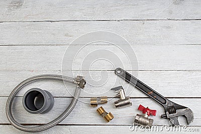 Fittings, pipe, valves, plastic pipe for water, water hose, adjustable wrench on the wooden background. Top view. Copy space for Stock Photo