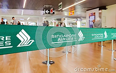 Green ribbon barrier with the Singapore airline logo inside the Leonardo da Vinci international airport in Rome Fiumicino in Italy Editorial Stock Photo