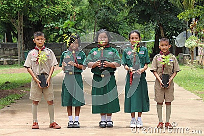 Five Asian students each hold the young plant. Editorial Stock Photo