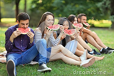 Five beautiful young people eating juicy ripe watermelon outdoor Stock Photo