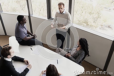 Five business people sitting at a conference table and discussing during a business meeting Stock Photo