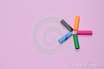 Five colorful pen cap on a pink millennial background. Space to insert the text. Office stuff. Minimalism. Stock Photo