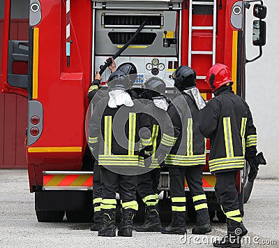 five firefighters with uniform and the fire truck during emergen Stock Photo