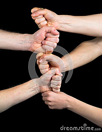 Five fists stacked on each other on a black background Stock Photo