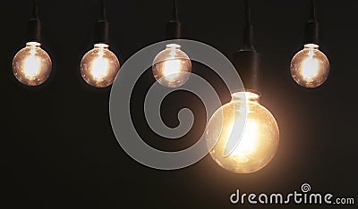 five hanging light bulb on black background. energy Stock Photo