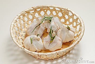 Five heads of garlic with sprouts lie in a basket on the table Stock Photo