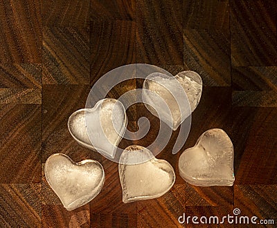 Five hearts made of ice on a dark wooden background Stock Photo