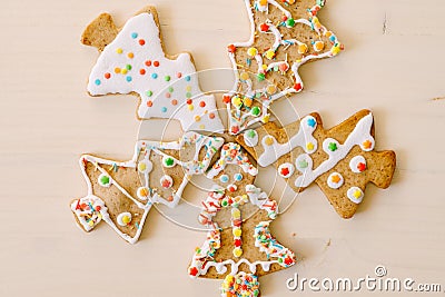 Five herringbone gingerbread cookies, differently decorated with glaze and sprinkles, set against a white painted wood Stock Photo