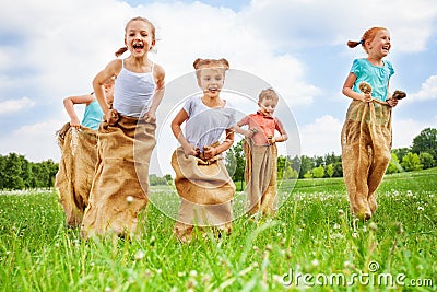 Five kids jump in sacks Stock Photo