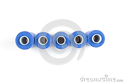 Five light blue sewing threads in a row on a white coils on a white background. Sewing supplies Stock Photo