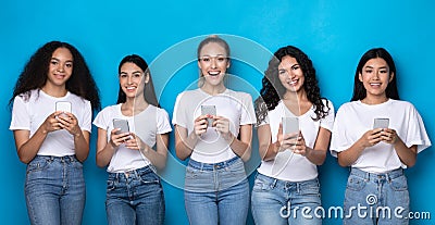 Five Multiracial Women Using Smartphones Over Blue Studio Background, Panorama Stock Photo