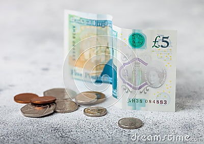 Five pounds banknote with coins on light background. Economy crisis concept Editorial Stock Photo