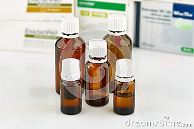 Five small brown medicine phials with pills packs on background. Stock Photo