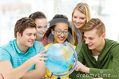 Five smiling student looking at globe at school Stock Photo