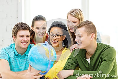 Five smiling student looking at globe at school Stock Photo