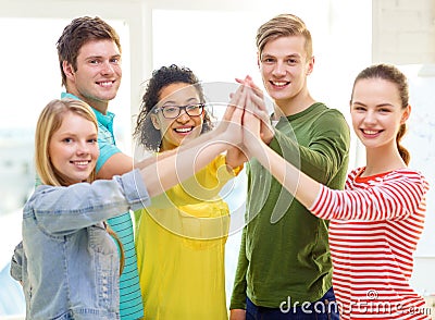 Five smiling students giving high five at school Stock Photo