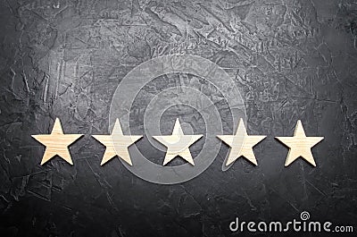 Five stars on a dark background. The concept of rating and evaluation. The rating of the hotel, restaurant, mobile application. Stock Photo