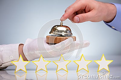 Five Stars In Front Of Person Ringing Service Bell Stock Photo