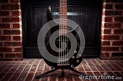 Five string bass guitar in front of fireplace Stock Photo