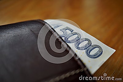 Five Thousand Czech Crown (CZK, Kc) bank note hanging accross a leather wallet Stock Photo