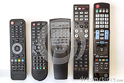 Five Used Remote Controls on White Background Stock Photo