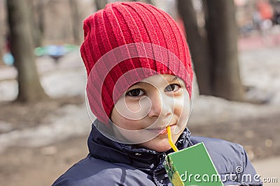 The child drinks juice in the Playground. emotional close-up portrait. Stock Photo