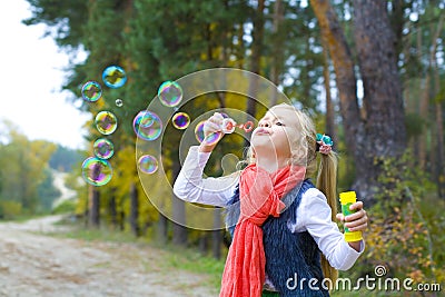 Five-year-old girl inflates soap bubbles Stock Photo