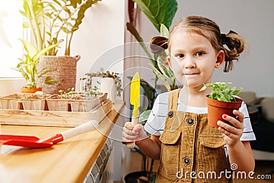 Five year old girl posing for a photo with a pot and gardening shovel in hands Stock Photo