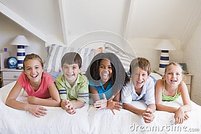 Five Young Friends Lying Down Next To Each Other Stock Photo