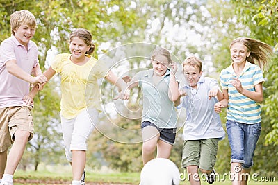 Five young friends playing soccer Stock Photo