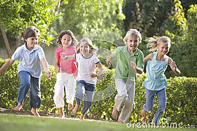 Five young friends running outdoors smiling Stock Photo