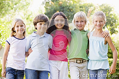 Five young friends standing outdoors smiling Stock Photo