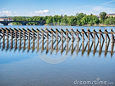 Fixed wooden logs forming a ice barrier near Charles Bridge on Vltava river, Prague Stock Photo