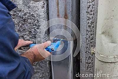 Fixing a leaky gutter downspout 2 Stock Photo