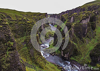 The Fjadra river flows through Fjadrargljufur Canyon: black rocks covered with soft green moss Stock Photo