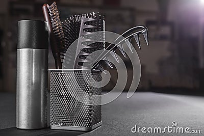 Flacon of hair spray near a basket with hairbrushes Stock Photo