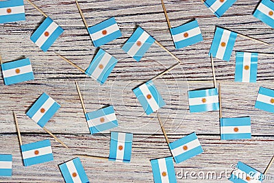 Flag of Argentina hanging on clothesline attached with wooden clothespins on aqua blue wooden background. National day concept Stock Photo