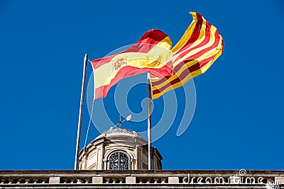 Flag of Catalonia. Senyera. Red and yellow striped flag and flag of Spain on clean blue sky background. Flag waving in the wind in Stock Photo